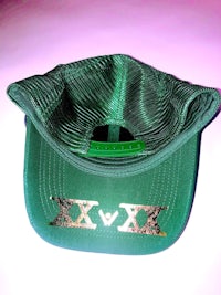 a green hat with an x on it