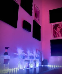 a room with purple lights and a bottle of water